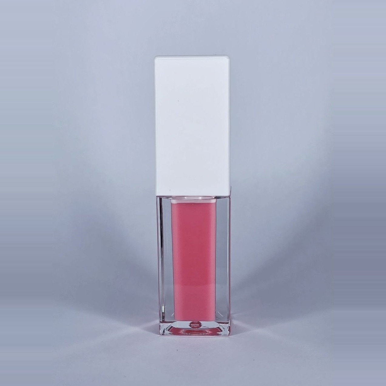 Pink Paradise pink lip gloss in a clear square bottle with a white cap